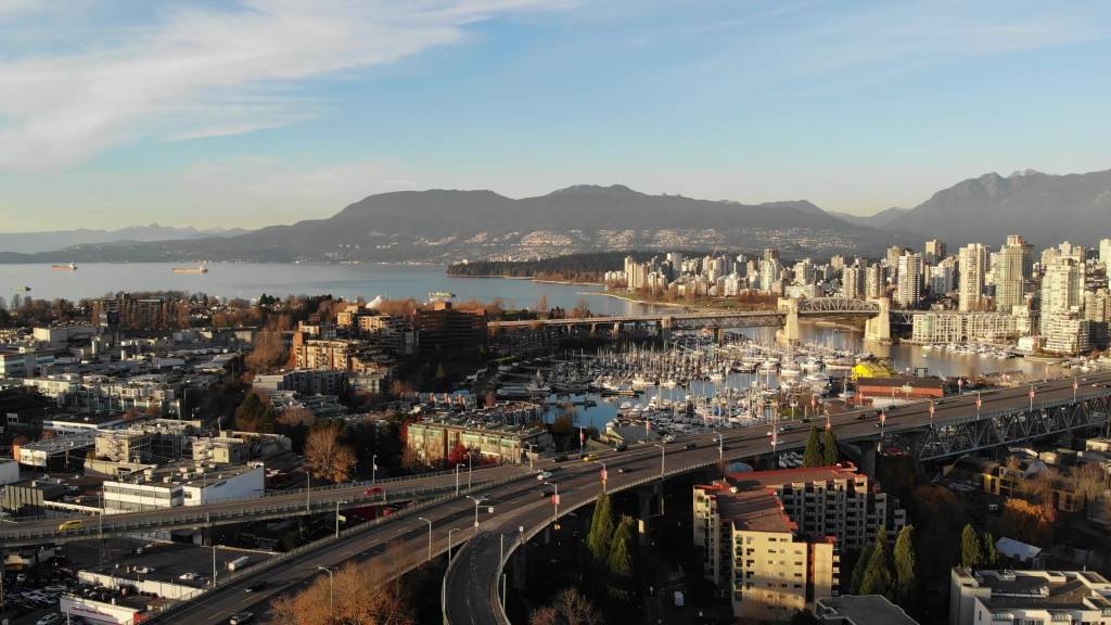 4K aerial view of Granville Island and False Creek Vancouver skyline with Burrard Bridge